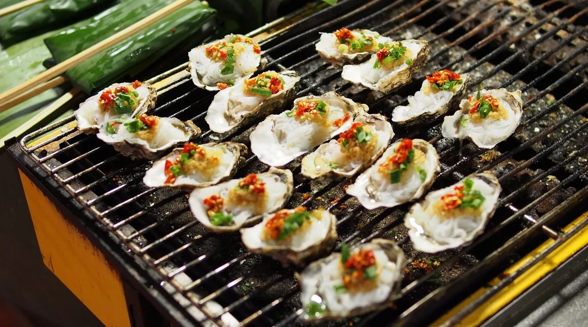 網の上で焼かれる殻付きの牡蠣